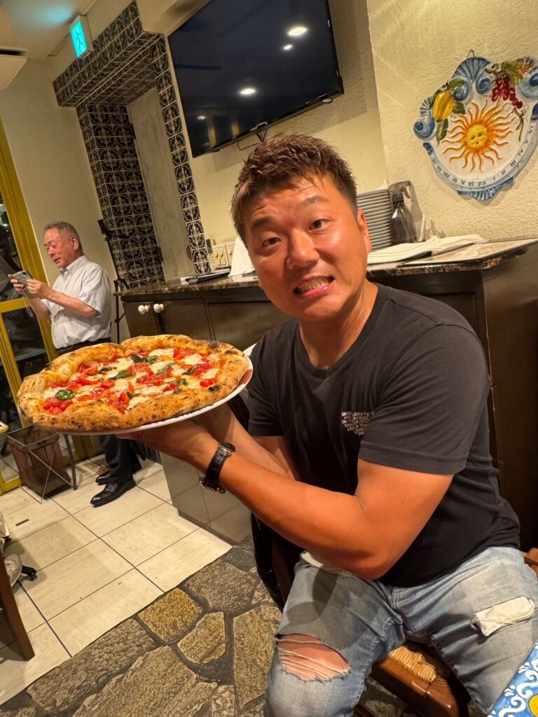 焼きあがったピッツァを手にする参加者